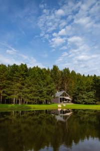 a house sitting on the shore of a lake at Māja Klusumā in Jaunķempji