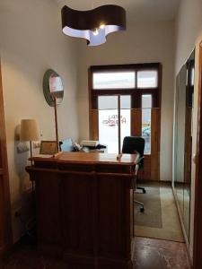 an office with a desk with a mirror and a window at Pensión Argüelles in Ribadesella