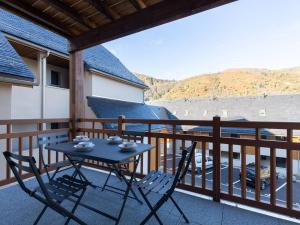 a table and chairs on a balcony with a view at À Loudenvielle, T2 moderne, proche télécabine, parking, wifi - FR-1-695-61 in Loudenvielle