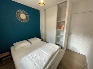 a small bedroom with a white bed and a blue wall at Cambo-les-Bains T2 avec piscine et WiFi, cosy pour 2 personnes - FR-1-495-143 in Cambo-les-Bains +8 photos