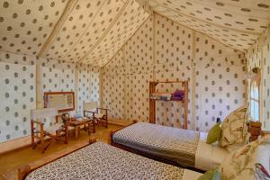 una habitación con dos camas y una mesa y sillas en Jaisalmer Winds Desert Camp, en Jaisalmer 40 fotos más