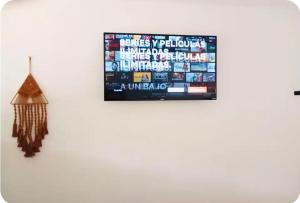 a television hanging on a wall with a flag on it at Evolution House Jungle Oasis in Hone Creek