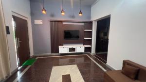 a living room with a television and a couch at Peaceful Getaway in Udupi Manipal in Udupi