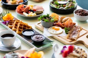 a table topped with plates of breakfast foods and coffee at The Marina Phuket Hotel in Patong Beach