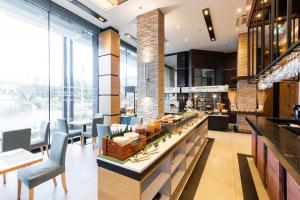 a restaurant with a counter with chairs and tables at The Marina Phuket Hotel in Patong Beach