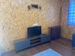 a living room with a tv and a wall at DorESA GUESTHOUSE in Macang
