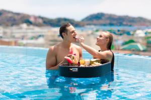 パトンビーチにあるThe Marina Phuket Hotelのスイミングプールの男女