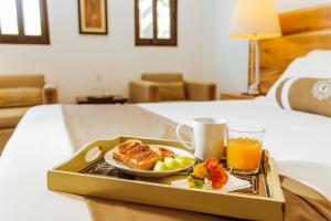 a tray with a plate of food and a drink on a bed at Casa Emiliana in Valle de Guadalupe