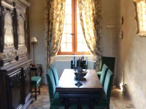 a dining room table with green chairs and a window at Gîte historique au château de charme proche du Mans - FR-1-410-453 in Saint Pavace