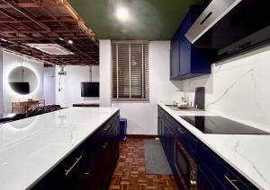 a kitchen with blue cabinets and white counter tops at Brown Brick Thonglor - Blue Blueberry Room in Klong Toi