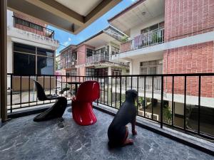 a balcony with sculptures of a dog and chairs at Brown Brick Thonglor - Blue Blueberry Room in Klong Toi