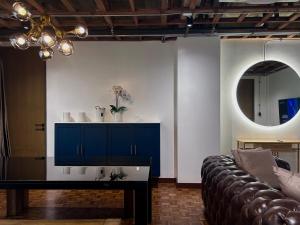 a living room with a couch and a mirror at Brown Brick Thonglor - Blue Blueberry Room in Klong Toi