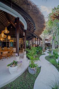 un complejo con un patio con mesas y macetas en Villa Coconut Heaven by Bali Villa Solutions, en Seminyak