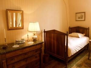 a bedroom with a bed and a lamp on a dresser at Gîte historique au château de charme proche du Mans - FR-1-410-453 in Saint Pavace