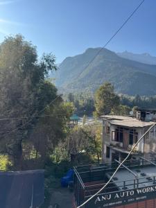 an old building with a mountain in the background at aashini homestay in Vashisht