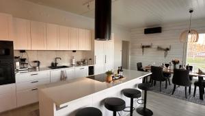 a kitchen with white cabinets and a table with chairs at Villa Sofia In Lapland in Tornio