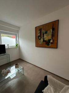 蒙斯Chambre neuve 1 ou 2 personnes的客厅配有桌子和墙上的绘画