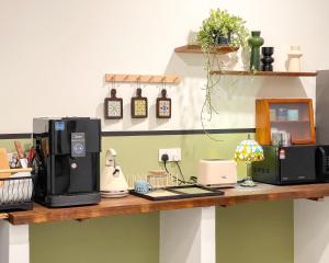 a counter with a coffee maker and a microwave on it at INN Lebuh Melayu in George Town