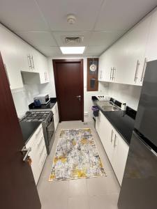 MawāliḩにあるLuxury apartment with cozy furnitureのキッチン(白いキャビネット、敷物付) +8枚の写真