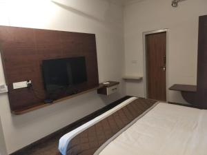 KolārOlivia Resort and Spa a unit of Falgu Resorts Pvt Ltd的一间配有床和平板电视的酒店房间