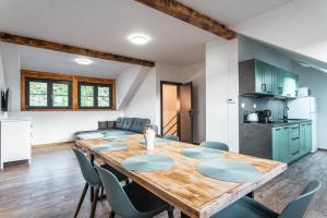 Una cocina y un comedor con mesa y sillas de madera. en Apartmány Quattro, en Loucná pod Klínovcem