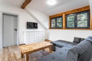 una sala de estar con un sofá y una mesa en Apartmány Quattro, en Loucná pod Klínovcem