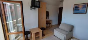 a small room with a chair and a television at Anchors Guest House in Sozopol
