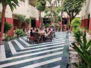 a group of people sitting at a table in a courtyard at HOTEL TOURIST REST HOUSE Agra in Agra