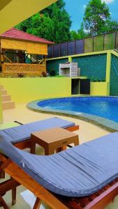 a swimming pool with a table and a swimming pool at Restu adel in Cisarua