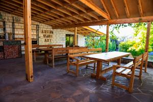 a pavilion with wooden tables and benches on a patio at Areni Wine Art in Areni