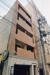 un grand bâtiment en briques devant un bâtiment dans l'établissement Campass202 1 minute from subway no elevator city center Freewifi, à Osaka