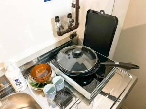 une poêle assise au-dessus d'une cuisinière dans l'établissement Campass202 1 minute from subway no elevator city center Freewifi, à Osaka 1 autre photo