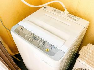 Gros plan d'une machine à laver contre un mur dans l'établissement Campass202 1 minute from subway no elevator city center Freewifi, à Osaka