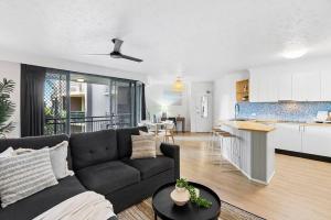 a living room with a couch and a kitchen at Stylish 2-BR Apartment in Gold Coast