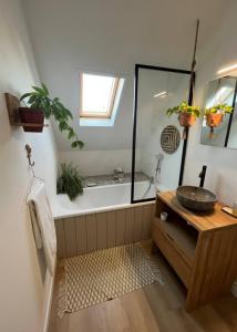 a bathroom with a tub and a sink at Chambre et salle de bain privée in Santes