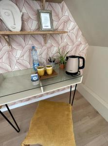 a shelf with a table with a water bottle and plants at Chambre et salle de bain privée in Santes