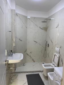 un bagno bianco con lavandino e WC di Shkodra Downtown Gem a Shkodër