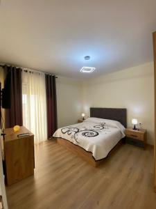 una camera con un grande letto e due comodini di Shkodra Downtown Gem a Shkodër