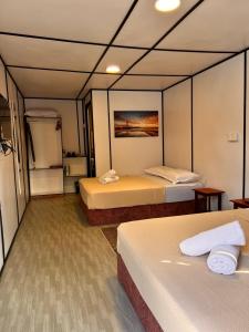 a hotel room with two beds and a refrigerator at Villa Wanie Cottage in Setiu +22 photos