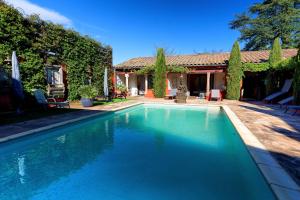 a swimming pool in front of a house at Couleurs du Sud in Vallon-Pont-dʼArc