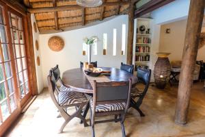 a dining room with a wooden table and chairs at Afrikhaya Guest House in St Lucia