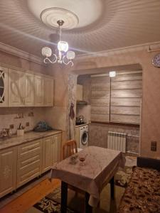 a kitchen with a table and a chandelier at Sweet Home Baku in Baku