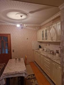 a kitchen with a table and a chandelier at Sweet Home Baku in Baku +23 photos