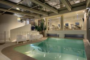 a large swimming pool with white chairs and a swimming pool at Hotel Romagna in Cattolica