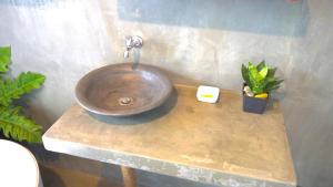 a bathroom sink with a copper bowl on a counter at Dins Nature Villa in Elgiriya