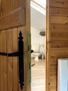 a door to a bathroom with a toilet in a room at Maison Au bois du Haut Folin in Saint-Prix