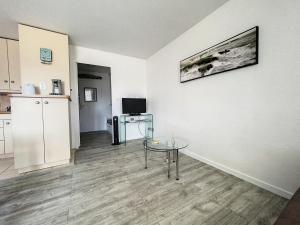 a living room with a table and a kitchen at La Bolee d Air in Quiberon