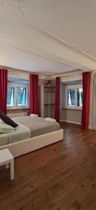 Un dormitorio con dos camas y cortinas rojas. en B&B Italian Guest Genova, en Génova