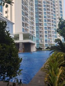 a swimming pool in front of some tall buildings at Ancol Mansion Apartment Sea View by Berlin Village in Jakarta