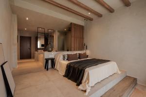 a bedroom with a large bed and a bathroom at Tesoro Elegant escapes- suites in Naxos Chora